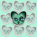 Mint-green cat face with two large blue-green eyes, three smaller eyes above one main eye, another below it, pointed ears and two small white fangs.